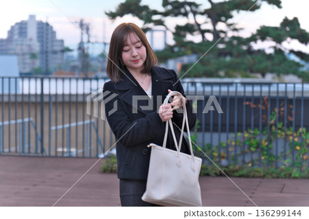 一位身著冬裝的日本女大學生背著書包站在屋頂上。這幅畫象徵著她通勤上學、外出活動以及開啟新生活。 一位身著冬裝的日本女大學生背著書包站在屋頂上。這幅畫象徵著她通勤上學、外出活動以及開啟新生活。 136299144