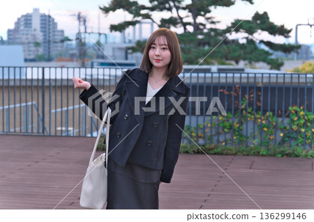 一位身著冬裝的日本女大學生背著書包站在屋頂上。這幅畫象徵著她通勤上學、外出活動以及開啟新生活。 一位身著冬裝的日本女大學生背著書包站在屋頂上。這幅畫象徵著她通勤上學、外出活動以及開啟新生活。 136299146