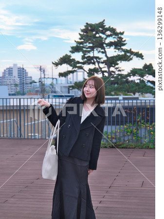 一位身著冬裝的日本女大學生背著書包站在屋頂上。這幅畫象徵著她通勤上學、外出活動以及開啟新生活。 136299148