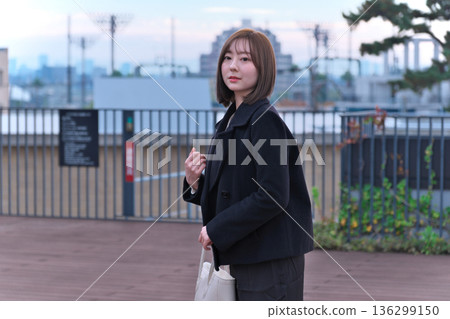 一位身著冬裝的日本女大學生背著書包站在屋頂上。這幅畫象徵著她通勤上學、外出活動以及開啟新生活。 一位身著冬裝的日本女大學生背著書包站在屋頂上。這幅畫象徵著她通勤上學、外出活動以及開啟新生活。 136299150