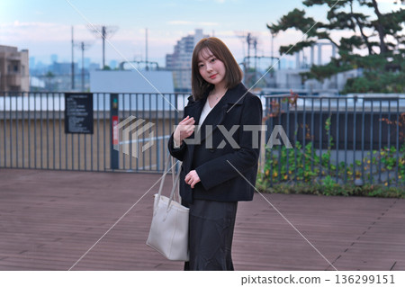一位身著冬裝的日本女大學生背著書包站在屋頂上。這幅畫象徵著她通勤上學、外出活動以及開啟新生活。 一位身著冬裝的日本女大學生背著書包站在屋頂上。這幅畫象徵著她通勤上學、外出活動以及開啟新生活。 136299151