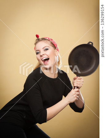 Retro styled woman having fun with kitchen accessories. Retro styled woman having fun with kitchen accessories. 136299154