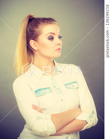Angry woman looking very displeased standing with arms folded Angry woman looking very displeased standing with arms folded 136299158