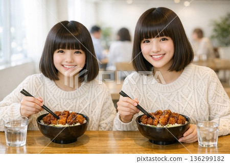 姊妹倆在餐廳吃沾醬豬排飯 姊妹倆在餐廳吃沾醬豬排飯 136299182