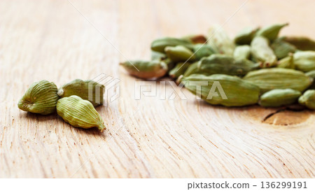 Green cardamom pods on wooden background 136299191
