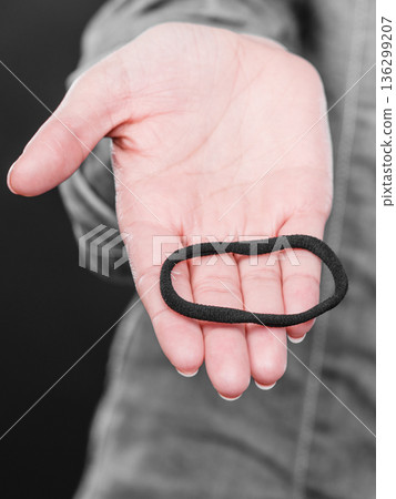 Female hand with elastic hair. 136299207