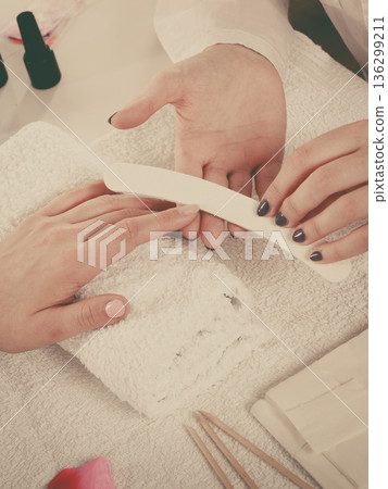 Woman getting manicure done file nails 136299211