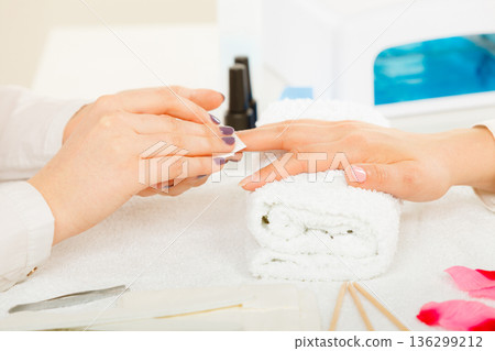 Woman making manicure using nail polish remover 136299212