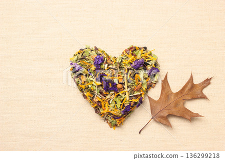 Dried herb leaves heart shaped on burlap surface 136299218