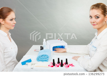 Professional manicurist painting woman nails. 136299273