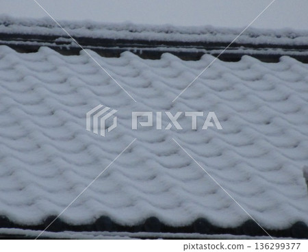 覆蓋著積雪的屋頂瓦片 覆蓋著積雪的屋頂瓦片 136299377