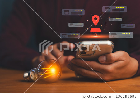 Person using smartphone with glowing local store icons, map pin, and star ratings, symbolizing online business reviews, location search, local SEO, and digital marketing for small businesses. Person using smartphone with glowing local store icons, map pin, and star ratings, symbolizing online business reviews, location search, local SEO, and digital marketing for small businesses. 136299693