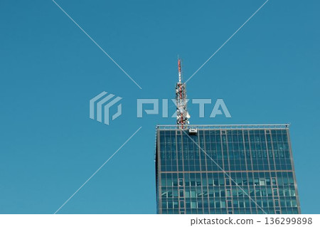 Modern glass skyscraper in Belgrade with antenna and clear sky 136299898