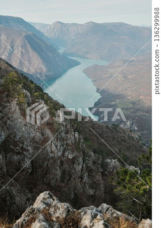 View of Perucac Lake stretching through mountain canyon from rocky viewpoint in Tara National Park, Serbia. Dramatic natural landscape with steep slopes View of Perucac Lake stretching through mountain canyon from rocky viewpoint in Tara National Park, Serbia. Dramatic natural landscape with steep slopes 136299988