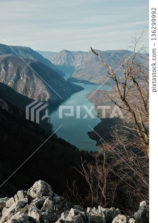 View of Perucac Lake stretching through mountain canyon from rocky viewpoint in Tara National Park, Serbia. Dramatic natural landscape with steep slopes View of Perucac Lake stretching through mountain canyon from rocky viewpoint in Tara National Park, Serbia. Dramatic natural landscape with steep slopes 136299992