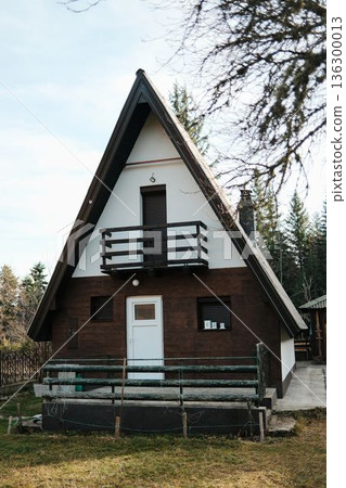 Front view of alpine style wooden cabin surrounded by forest vegetation in Tara National Park, Serbia. Quiet mountain home in wilderness Front view of alpine style wooden cabin surrounded by forest vegetation in Tara National Park, Serbia. Quiet mountain home in wilderness 136300013
