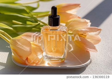 facial serum with vitamin C or organic oil in cosmetic dropper bottle on white tray with tulips in the sun. view. additional care. Natural cosmetics facial serum with vitamin C or organic oil in cosmetic dropper bottle on white tray with tulips in the sun. view. additional care. Natural cosmetics 136300119