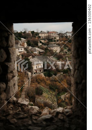 Stone houses of the historic Pocitelj old town on a hillside, surrounded by autumn vegetation, viewed from inside the walls of Pocitelj Fortress 136300402