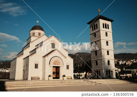 Orthodox church and bell tower standing together in Andricgrad, Visegrad, Bosnia and Herzegovina. Architectural ensemble reflects spiritual harmony and cultural heritage 136300556