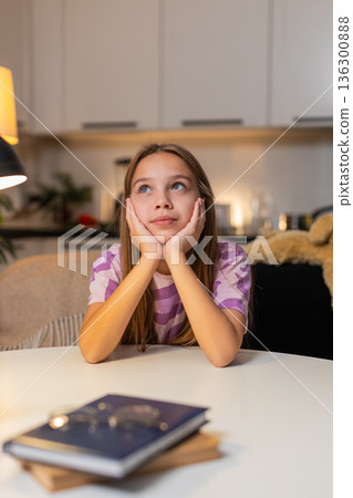 Teenager girl rests chin on hands looks up thinking about future gentle smile dreamy calm mood sweet Teenager girl rests chin on hands looks up thinking about future gentle smile dreamy calm mood sweet 136300888