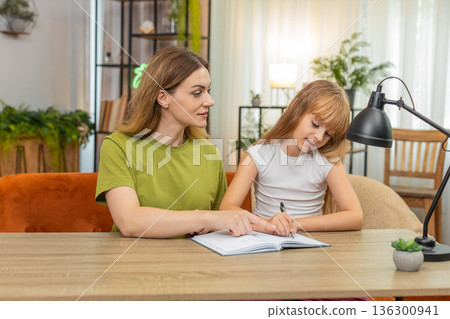 Mother daughter check math answer at table mark ticks say hooray sums notebook pen focus steps again Mother daughter check math answer at table mark ticks say hooray sums notebook pen focus steps again 136300941