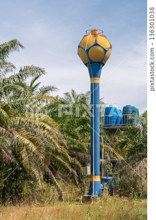 A Water Tower Painted as a Giant Soccer Ball: Blue and Yellow Hexagon Design on a Tall Blue Column with Yellow Stripes, Surrounded by Tropical Palms on Koh Kho Khao, Thailand. High quality photo A Water Tower Painted as a Giant Soccer Ball: Blue and Yellow Hexagon Design on a Tall Blue Column with Yellow Stripes, Surrounded by Tropical Palms on Koh Kho Khao, Thailand. High quality photo 136301038
