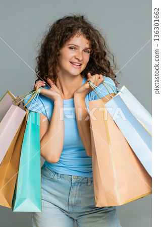 Woman holding shopping bags advertising discounts promoting sale campaign cheerful happy shopper 136301662