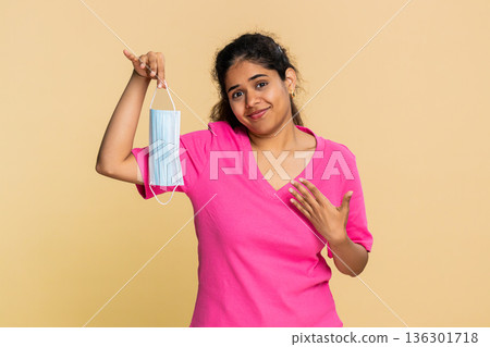 Indian woman happily removes medical mask, breathing relief deeply with bright joyful smile 136301718