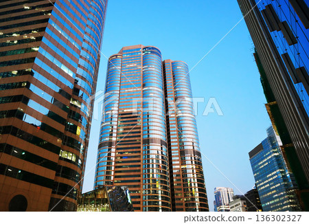 Skyscrapers tower bright glass exteriors sunlight sunset. Facade office buildings. 136302327