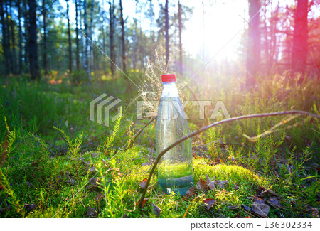Plastic bottle with fresh drinking water on forest background. Plastic bottle with fresh drinking water on forest background. 136302334