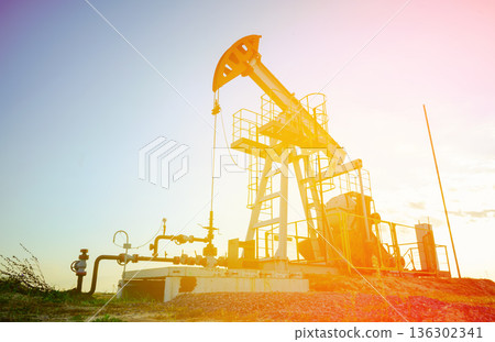Pumpjack in oil well of oil field on sunrise in Industrial crude area. Crude pump jack oil field Pumpjack in oil well of oil field on sunrise in Industrial crude area. Crude pump jack oil field 136302341