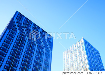 Glass building in sunset. Facade of new modern business office building. Glass building facade Glass building in sunset. Facade of new modern business office building. Glass building facade 136302344