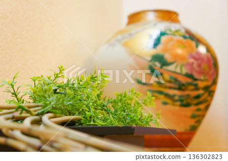 一隻彩繪精美的花瓶和一株小巧的植物 136302823