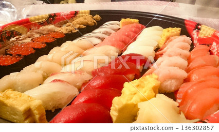 為慶祝而訂購的壽司外賣,裡面塞滿了各種配料。 為慶祝而訂購的壽司外賣,裡面塞滿了各種配料。 136302857