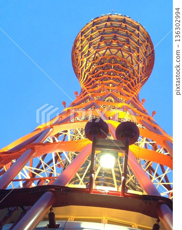 Kobe Port Tower stretches into the sky - its beautiful vermilion structure shining at dusk Kobe Port Tower stretches into the sky - its beautiful vermilion structure shining at dusk 136302994