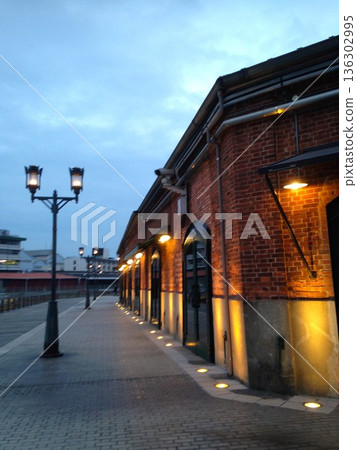 Kobe Harborland at dusk: Red Brick Warehouse and a quiet promenade lined with gas lamps Kobe Harborland at dusk: Red Brick Warehouse and a quiet promenade lined with gas lamps 136302995