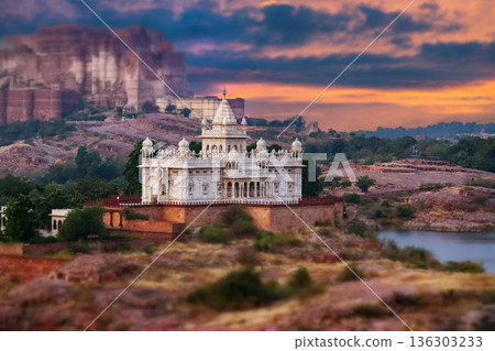 Scenic view of the white marble Jaswant Thada cenotaph in Jodhpur, Rajasthan, surrounded by rocky hills and a tranquil lake at sunset. Scenic view of the white marble Jaswant Thada cenotaph in Jodhpur, Rajasthan, surrounded by rocky hills and a tranquil lake at sunset. 136303233