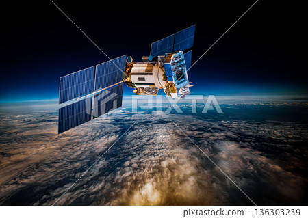Detailed view of a satellite in space, featuring metallic structure, antennas, and large solar panels, orbiting above Earth's blue atmosphere and orange-tinted cloud layers against the dark void. Detailed view of a satellite in space, featuring metallic structure, antennas, and large solar panels, orbiting above Earth's blue atmosphere and orange-tinted cloud layers against the dark void. 136303239