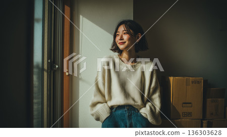 /* 一位女性搬家後在新家開始新生活的平靜室內場景 */ 136303628