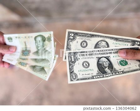 US dollar and Chinese yuan banknotes arranged together, representing global finance, international economy, currency value, foreign markets, investment strategy, and worldwide economic connections US dollar and Chinese yuan banknotes arranged together, representing global finance, international economy, currency value, foreign markets, investment strategy, and worldwide economic connections 136304062
