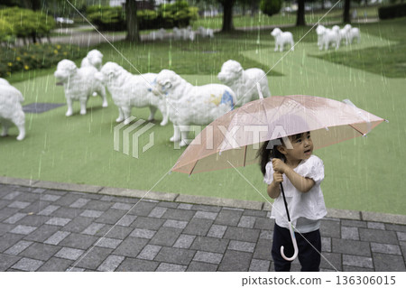 女孩撐著傘在公園散步。 136306015