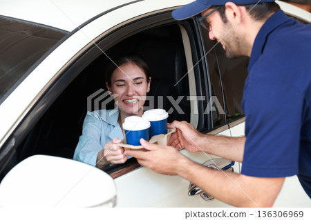 Hand Man in car receiving coffee in drive thru fast food restaurant. 136306969