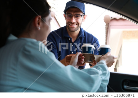Hand Man in car receiving coffee in drive thru fast food restaurant. 136306971