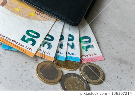 Black partmone with euro money. Coins and bills in leather wallet for commerce concept. Black partmone with euro money. Coins and bills in leather wallet for commerce concept. 136307214