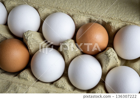 White and brown fresh eggs. Nature background. Chicken egg in carton box for cooking healthy food. Bio organic eggs on the farm. 136307222