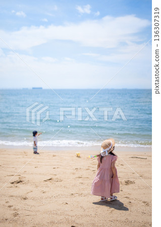 豎幅照片，展現孩子們在海裡和沙灘上玩耍的場景。 136307319