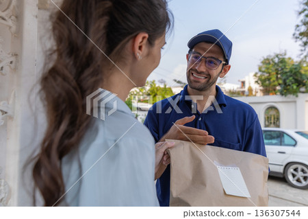 Delivery express courier young man use giving boxes or Food to woman customer at front home. Delivery express courier young man use giving boxes or Food to woman customer at front home. 136307544