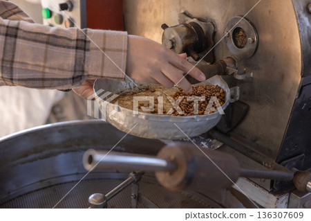 Coffee processing. Coffee roasting machine with arabica beans in stainless steel cooling bin. Coffee processing. Coffee roasting machine with arabica beans in stainless steel cooling bin. 136307609