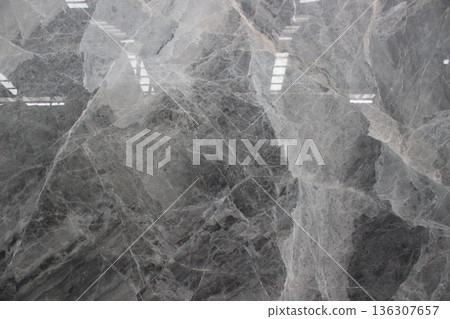 Dark grey Grigio Carnico marble texture with contrasting and dramatic white crystal fracture patterns. 136307657