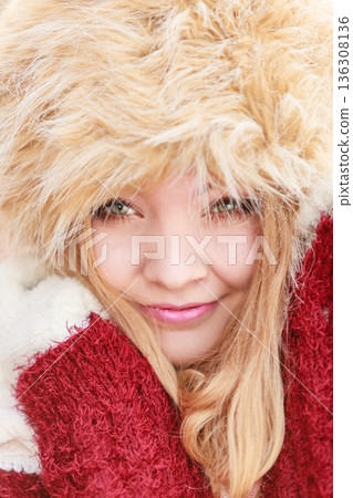 Portrait of pretty smiling woman in fur winter hat 136308136